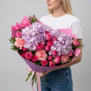 Пышный букет с лавандовой гортензией и розовыми пионовидными розами в сиреневой упаковке